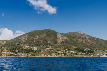 Fototapeta na wymiar Greek Island viewed from the sea. Beautiful sea landscapes on Island in Greece. In distance is famous Scorpios island, from the left side is Lefkada island and from right is a part of gorgeous