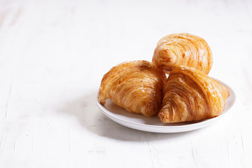 croissant on plate on wooden background.