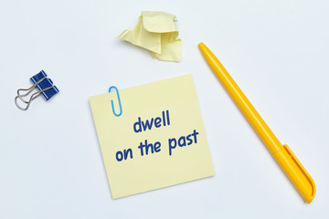English idiom hand lettering about time - dwell on the past on wooden blocks.