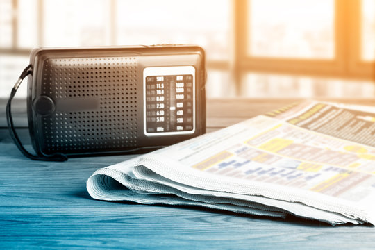 Radio and newspapers on the office desk, media breaking news concept.