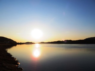 Fototapeta na wymiar 日本の田舎の風景　12月　河川敷の夕景グラデーション　日没と水鏡