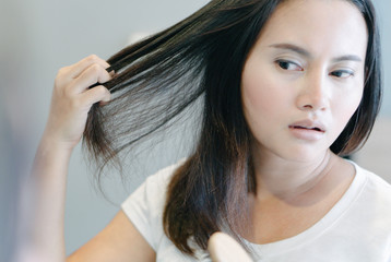 Fototapeta premium Close up woman hand holding hair loss problem for health care shampoo and beauty product concept