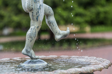 
Statue of a child splashing feet in the water.