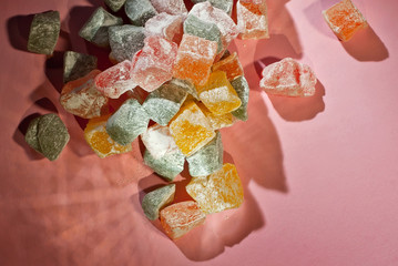 Lots of sweets on a pink background. Candy with white icing sugar close up.