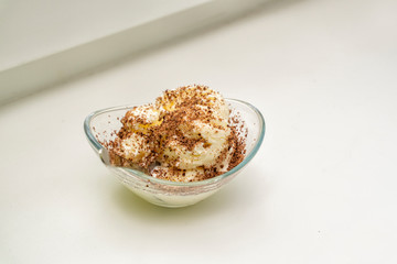 Bowl with delicious vanilla ice cream sprinkled with chocolate chips on a table on a light background