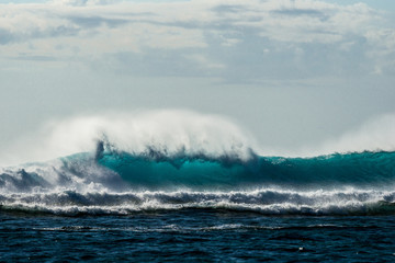 A huge wave for surfing . The photo was taken from the water in the Indian Ocean island of Mauritius