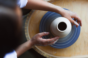 Hands working on pottery wheel