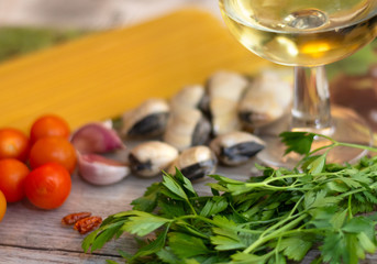 Ingredients for spaghetti alle vongole, an italian traditional recipe: spaghettis, clams, tomatoes, garlic, chilli, parsley and white wine