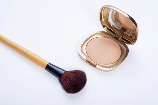 Powder For Make Up In Golden Container On A White Background And With Brush. Space For Text