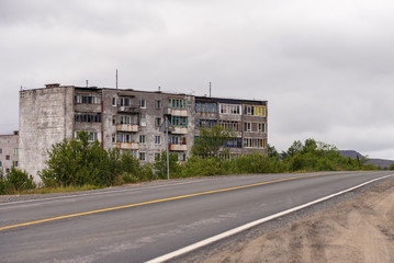Facade of old grey multi-storey soviet panel building