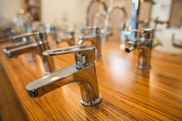 Assortment of water taps on a wooden stand from blurred background