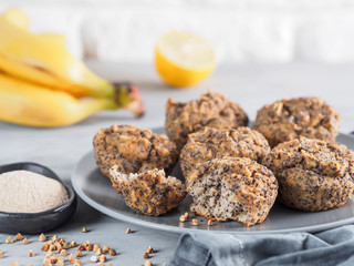 Close-up view of healthy gluten-free homemmade banana muffins with buckwheat flour. Vegan muffins with poppy seeds on gray plate over gray wooden table. Copy space