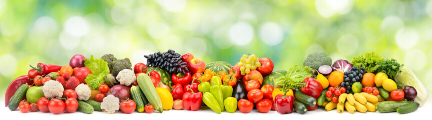 Panoramic photo fruits and vegetables on green blurred background