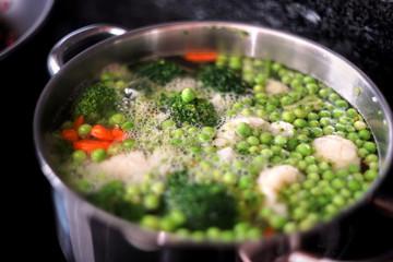 pot with boiling water and vegetables