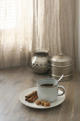 Coffee with cinnamon and silver utensils