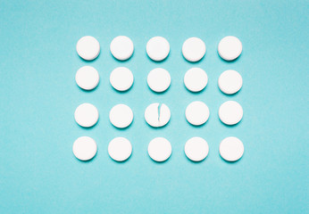 Round, white pills on a blue background. The concept of the treatment of the disease