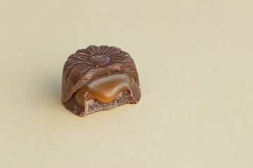 Chocolate candy with caramel filling in the cut. Close up. Copy space for text