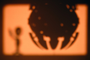 The alien shadow and the spaceship, the concept of contact. UFO silhouette in the orange mystical...