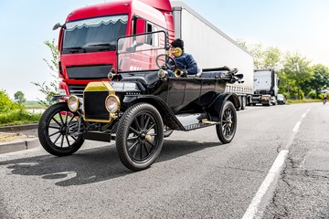 Retro car fragment . Black old car on the modern street of the city