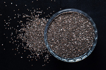Chia seeds in a cup beautifully laid out on a black background. Top view. copy space. Vegetarian food.