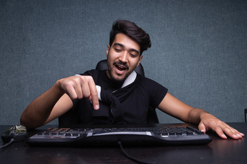 A young guy presses enter on the keyboard. on a gray background.