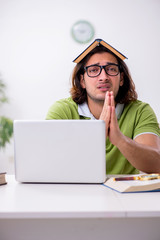 Young male student preparing for exams at home