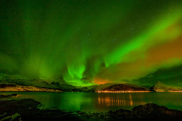 Aurora borealis on the Lofoten islands, Norway. Green northern lights above mountains. Night sky...