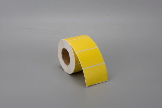A roll of yellow thermal label printing paper