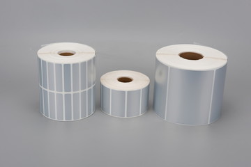 A few rolls of silver thermal print label paper