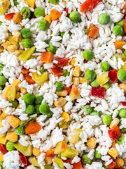 Frozen vegetables assorted, close up view. Assorted frozen vegetables food with ice, top view or flat lay. Raw uncooked frozen hawaii mix.