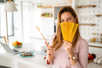 Happy joyful woman holding long pasta macaroni ready to cook. Healthy food concept.