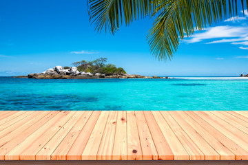 Wooden floor or plank on sand beach. For product display.Calm Sea and Blue Sky Background.tropical in summer.