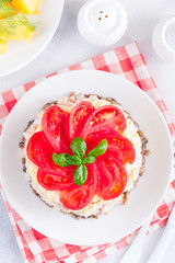 Festive layered salad with fried champignons, smoked chicken, eggs and cheese, garnished with fresh tomatoes, selective focus