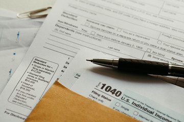 Individual income tax return form,  income tax return form and pen on desk