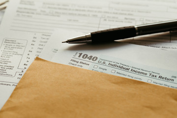 Individual income tax return form,  income tax return form and pen on desk