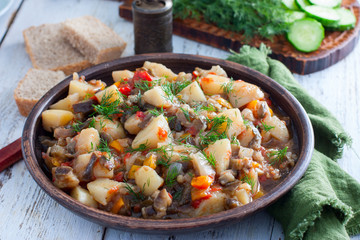 Vegetable stew with potatoes and eggplant in a clay bowl, vegetarian recipe, selective focus