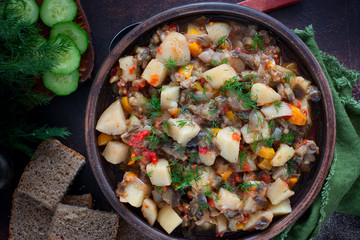 Vegetable stew with potatoes and eggplant in a clay bowl, vegetarian recipe, selective focus