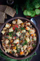 Vegetable stew with potatoes and eggplant in a clay bowl, vegetarian recipe, selective focus