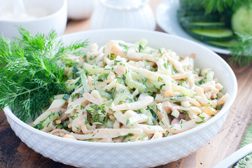 Salad with squid, eggs and fresh cucumbers, selective focus