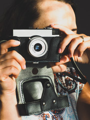 A woman with an old vintage film camera up to her eye