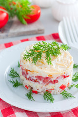 salad with crab sticks, tomatoes, cheese on a white dish, selective focus