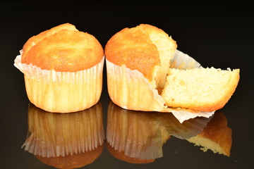 Fresh tasty muffins, close-up, on a black background.