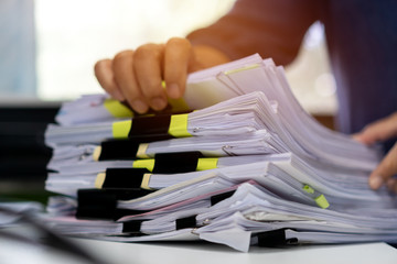 Stacks documents of paper files, Businessman hands working in messy bureaucracy and searching...