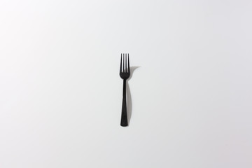 Plastic items. The black fork on a white background. For the presentation of waste recycling. Disposable tableware