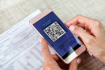 payment of utility bills by QR code without leaving the house, using a smartphone, the girl makes an on-line payment