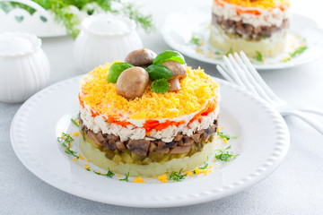 Beautiful festive layered salad with chicken, potatoes, carrots, pickles and fried champignons, selective focus