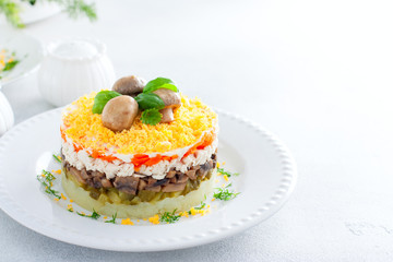 Beautiful festive layered salad with chicken, potatoes, carrots, pickles and fried champignons, copy space