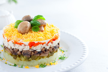 Beautiful festive layered salad with chicken, potatoes, carrots, pickles and fried champignons, copy space