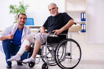 Old injured man visiting young male doctor traumatologist