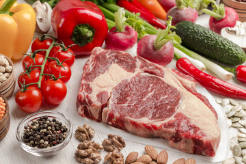 Marbled beef steak with vegetables, beans, nuts on white background.